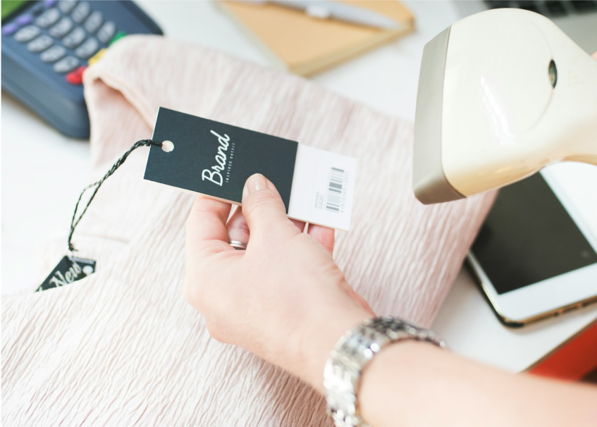 A store clerk scans a price tag with a barcode